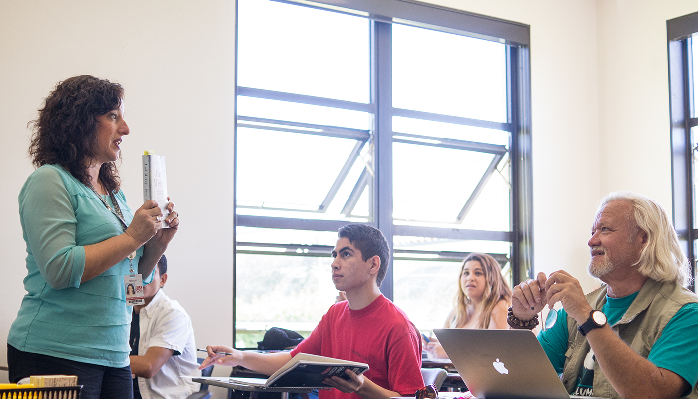 SBCC Professor Margaret Prothero teaches her class while holding a book.